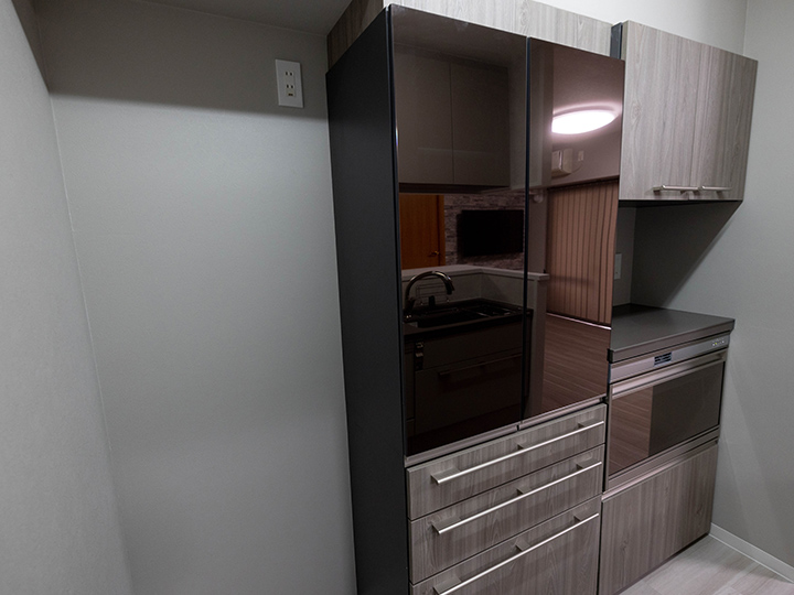 キッチンの背面には、キッチンのデザインと合わせた食器棚を設置しました。<br />
グレーを基調としたスタイリッシュな印象になりました。