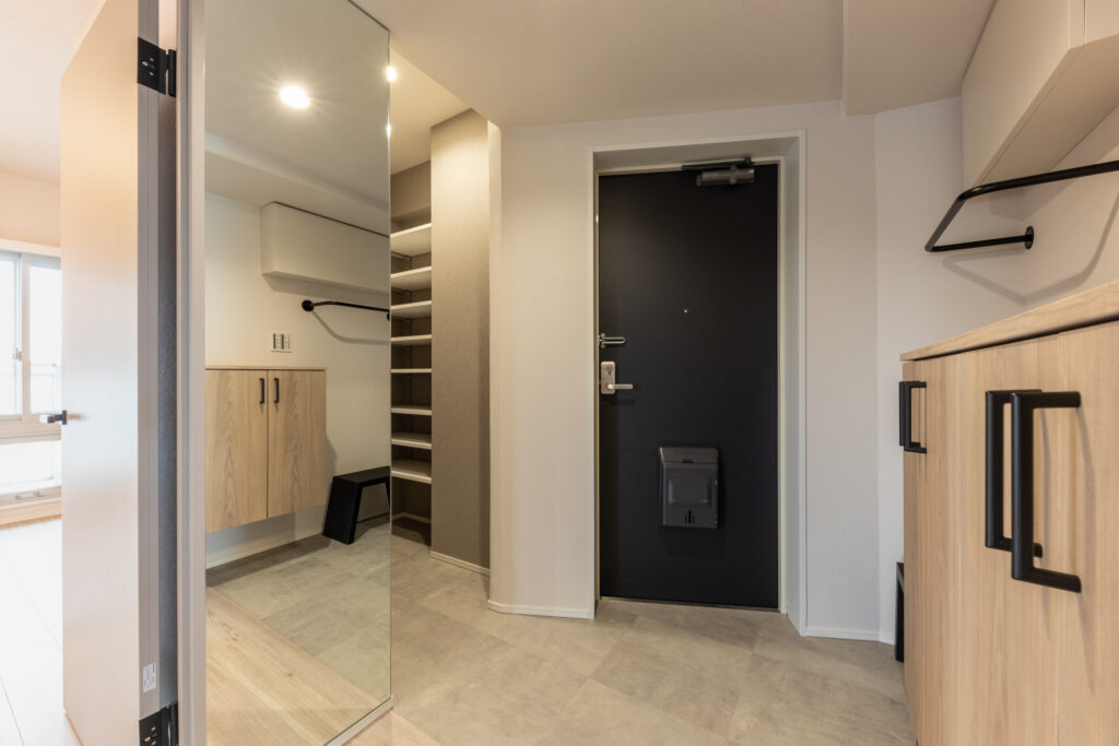 シューズクローゼットの扉は鏡タイプにすることで、外出時の身だしなみチェックに便利です。下足箱横のアイアンバーには、帰宅後ジャケットをかけたりとお使いいただけます。