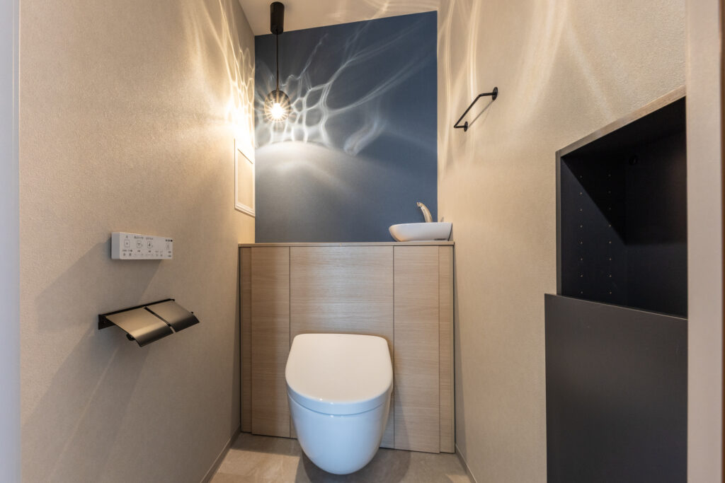 トイレはTOTOのレストパルF。<br />
床から浮いたフローティングデザインによる掃除のしやすさと、一体型キャビネットによる高い収納力が特徴です。水のゆらめきのような灯の表情が特徴のODELICのペンダントライトで、トレンドのおしゃれトイレに。<br />
キャビネットカラー<br />
ライトウッド